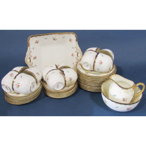 1018 - A Wedgwood tea service for 12 with rosebud detail, within a blue and gilt colourway comprising cups,... 