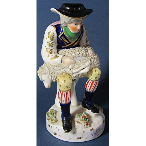 1049 - A 19th century Staffordshire figure of a farming shearing a ewe, together with a continental majolic... 