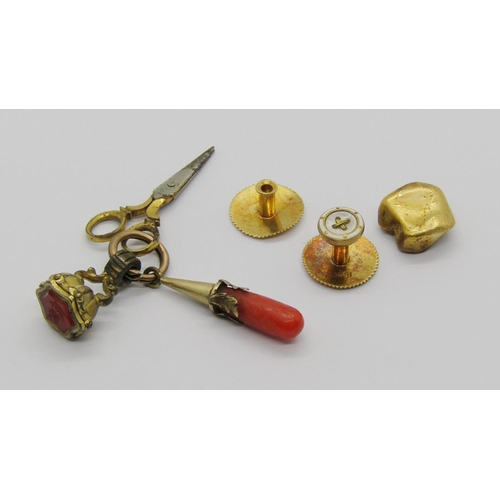 1314 - Victorian yellow metal fob with three charms; scissors, coral example and intaglio-cut seal depictin... 