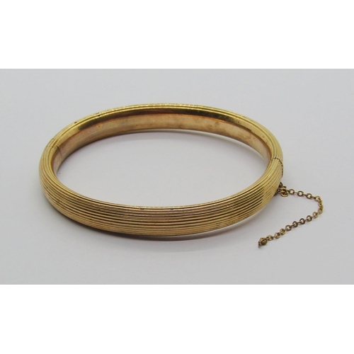 1326 - Yellow metal hinged bangle with ribbed finish, 13.6g