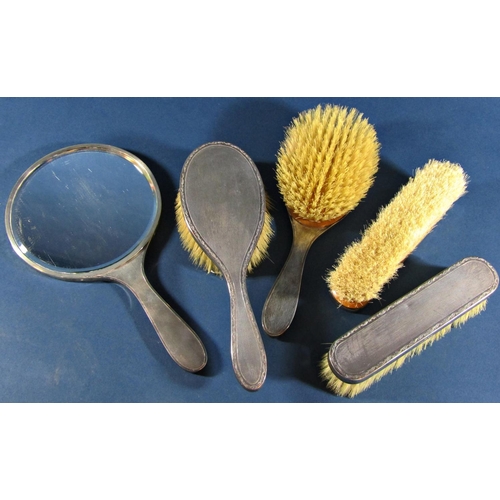 1223 - A five piece silver dressing table set comprising hand mirror, two hair brushes and two clothes brus... 