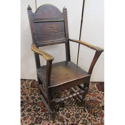 2675 - An 18th century oak elbow chair with panelled seat and back, turned supports, and rails