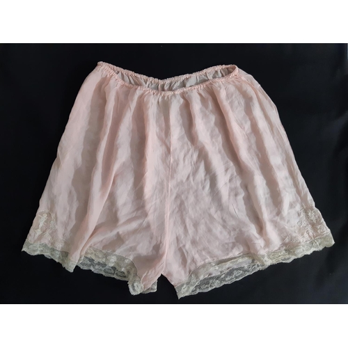 1551 - An impressive pair of vintage knickers in pale pink silk, trimmed with 19th century Flanders lace an... 