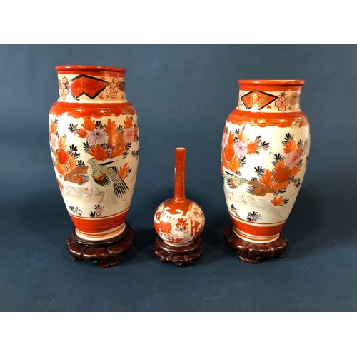 1054 - A pair of Imari baluster vases, 24cm high, another with slender neck, all on stands, a soapstone car... 