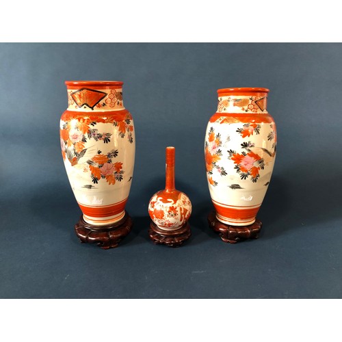 1054 - A pair of Imari baluster vases, 24cm high, another with slender neck, all on stands, a soapstone car... 