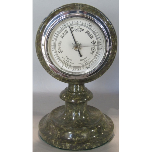 1631 - A Serpentine stone framed aneroid barometer and a further Serpentine stone table lamp in the form of... 