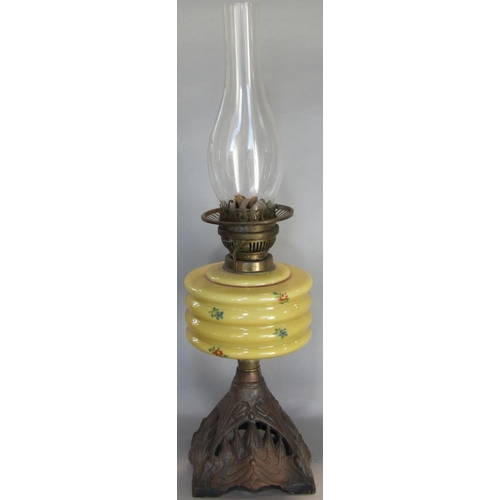 1650 - A Victorian oil lamp with mustard coloured font and cast iron base, together with further oil lamp b... 