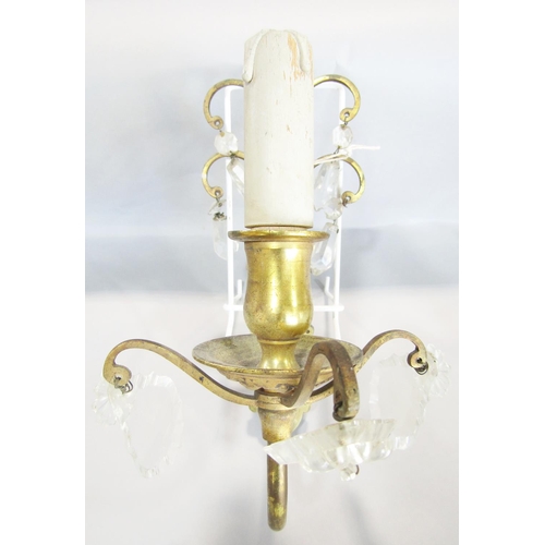 1565 - Set of four cast brass wall lights with scrolled backs, hung with cut glass drops