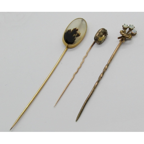 1394 - Three antique yellow metal stick pins to include an example with 15ct head set with three opals, 3.8... 