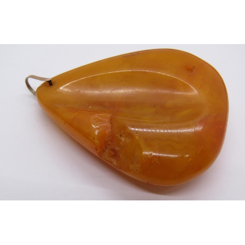 1409 - Large amber coloured pendant of organic form with yellow metal bale, 21.9g, together with a further ... 