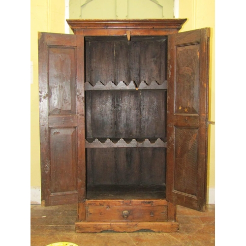 2569 - An Indian hardwood cupboard, enclosed by a pair of panelled doors with iron work fittings, the inter... 