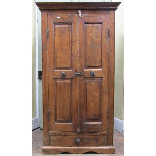 2569 - An Indian hardwood cupboard, enclosed by a pair of panelled doors with iron work fittings, the inter... 