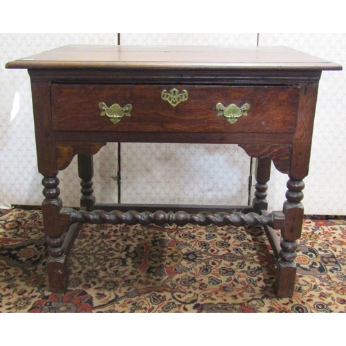 2625 - An antique oak side table with frieze drawer raised on bobbin moulded supports with barley twist rai... 