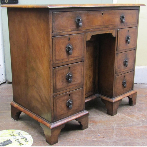 2637 - A Georgian style walnut kneehole writing desk the top quarter panelled, the front enclosing seven dr... 