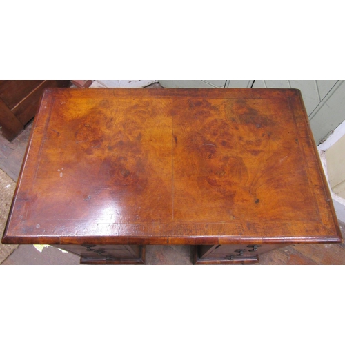 2637 - A Georgian style walnut kneehole writing desk the top quarter panelled, the front enclosing seven dr... 