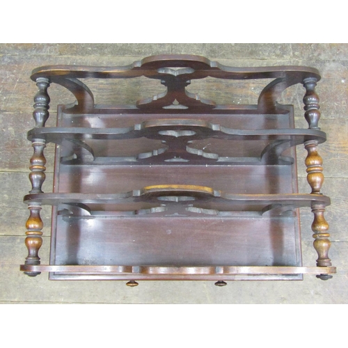 2656 - A Regency rosewood four divisional Canterbury with shaped and pierced outline, over a frieze drawer ... 