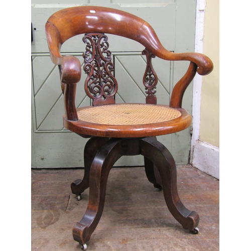 2665 - A Victorian walnut office chair with shoe shaped back over a circular cane work seat, with swivel ba... 