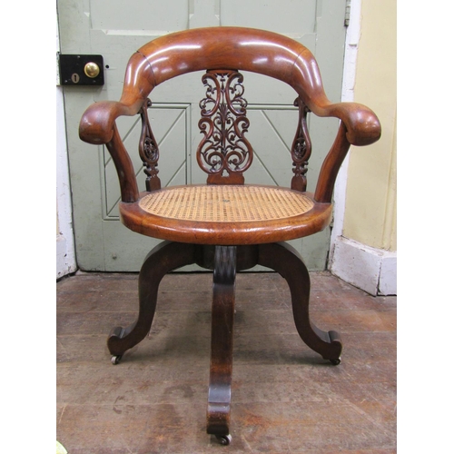 2665 - A Victorian walnut office chair with shoe shaped back over a circular cane work seat, with swivel ba... 