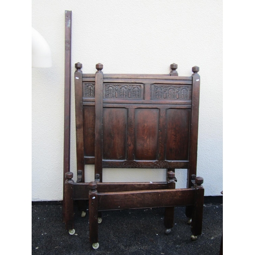 2516 - A pair of old English oak single bedsteads the carved and panelled backs with repeating geometric ca... 