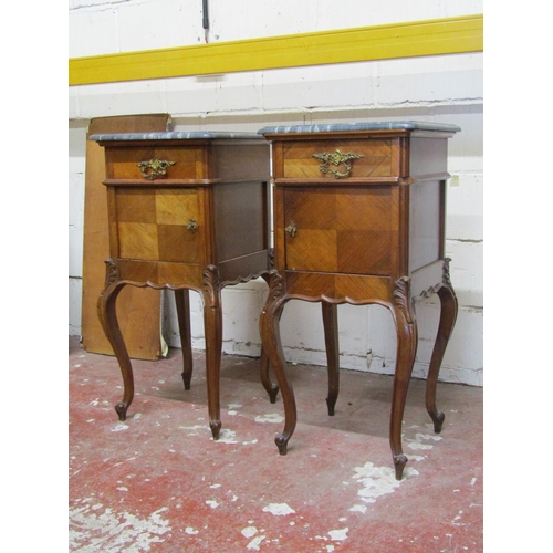 2523 - A pair of walnut bedside cabinets, the front elevation enclosed by a frieze drawer over a cupboard r... 