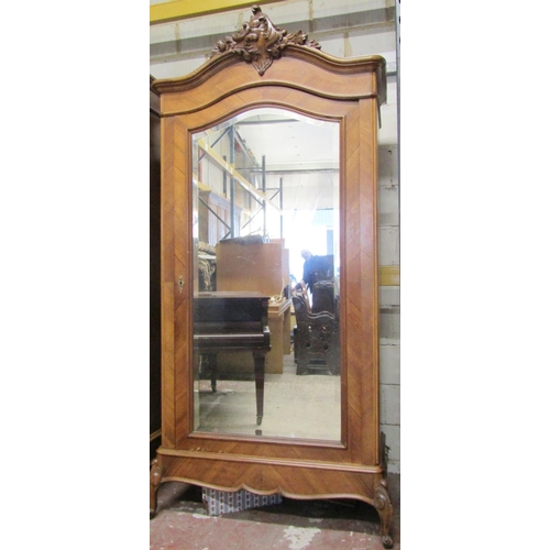 2524 - A walnut veneered armoire, the single mirror panelled door with bevelled edge plate set within chevr... 