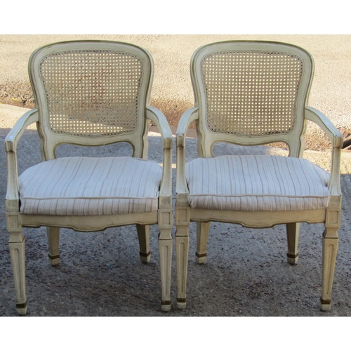 2529 - A pair of contemporary open elbow chairs the cane panelled backs, upholstered seats on square taper ... 