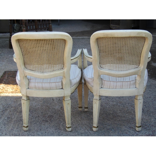 2529 - A pair of contemporary open elbow chairs the cane panelled backs, upholstered seats on square taper ... 