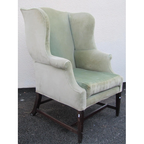 2545 - A substantial Georgian style wing chair with scrolled arms, upholstered in green velvet on square ta... 