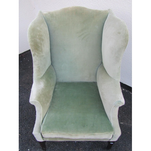 2545 - A substantial Georgian style wing chair with scrolled arms, upholstered in green velvet on square ta... 