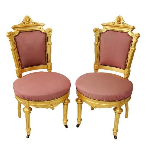 2574 - A pair of 19th century French side or salon chairs with shaped and gilded frames, upholstered seats ... 