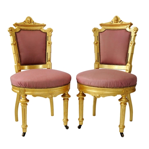 2574 - A pair of 19th century French side or salon chairs with shaped and gilded frames, upholstered seats ... 