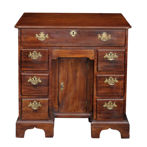 2601 - An 18th century mahogany and oak lined kneehole writing desk the central cupboard surrounded by an a... 