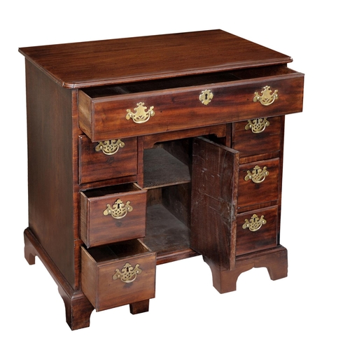 2601 - An 18th century mahogany and oak lined kneehole writing desk the central cupboard surrounded by an a... 