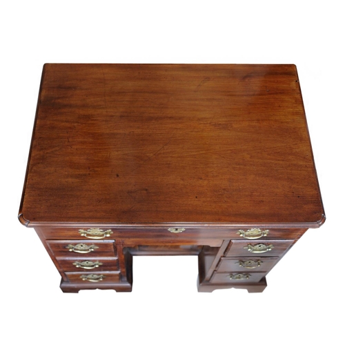 2601 - An 18th century mahogany and oak lined kneehole writing desk the central cupboard surrounded by an a... 