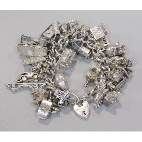 1412 - Good silver charm bracelet hung with thirty novelty charms to include 'Ye Olde Smithy', diving helme... 