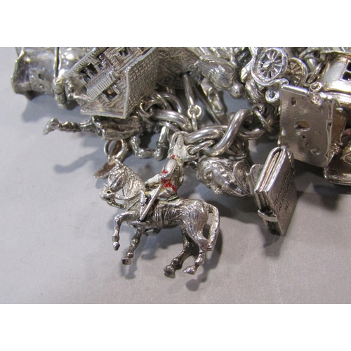 1412 - Good silver charm bracelet hung with thirty novelty charms to include 'Ye Olde Smithy', diving helme... 