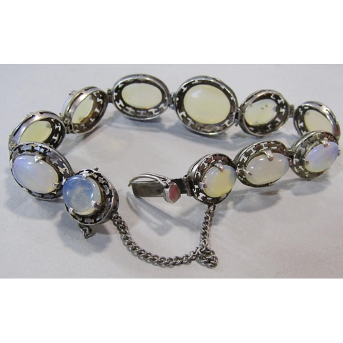 1415 - White metal bracelet set with graduated opalescent cabochons, together with a pair of silver earring... 