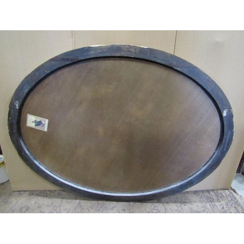 2410 - A large oval antique style wall mirror with bevelled edge plate within a scrolled and simulated craz... 
