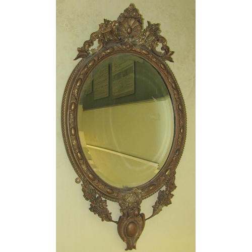 2668 - A Victorian gesso mirror, the bevelled edge mirror plate of oval form, the frame with repeating oak ... 