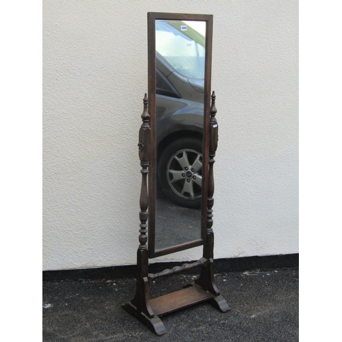 2555 - An old English style oak cheval glass raised on turned column supports and platform base, together w... 