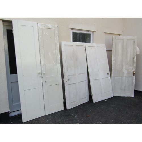 2557 - Four 19th century panelled pine doors including one working as a pair of doors, all with painted fin... 