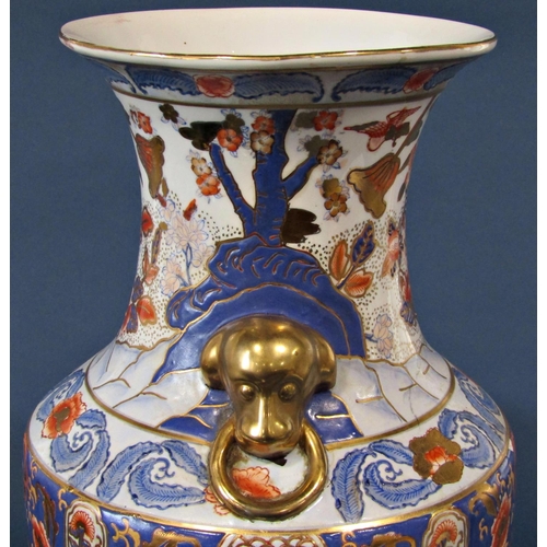 1057 - A Chinese oviform vase in a red, blue and gold colourway showing repeating bands of flowering plants... 