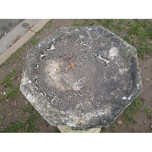 2013 - A weathered cast composition stone two sectional bird bath with octagonal top raised on a baluster p... 