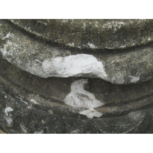 2026 - A weathered marble urn of squat globular form with relief detail set/raised on a later associated sq... 