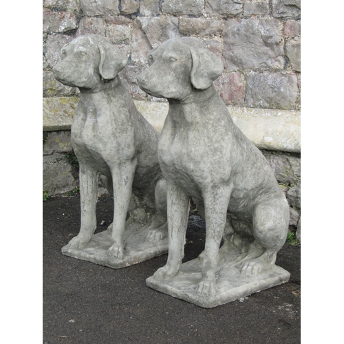 2076 - A pair of cast composition stone garden ornaments in the form of seated hounds 70 cm high