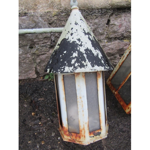 2073 - A vintage iron work wall mounted exterior lantern of octagonal form with conical roof and scroll wor... 