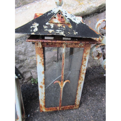 2073 - A vintage iron work wall mounted exterior lantern of octagonal form with conical roof and scroll wor... 