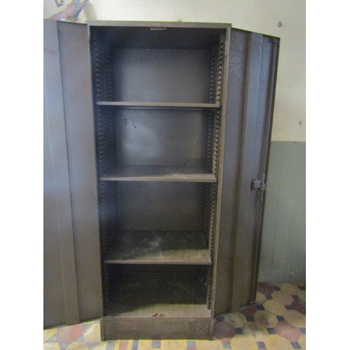 2082 - A vintage industrial steel floorstanding side cabinet enclosed by a pair of full length rectangular ... 