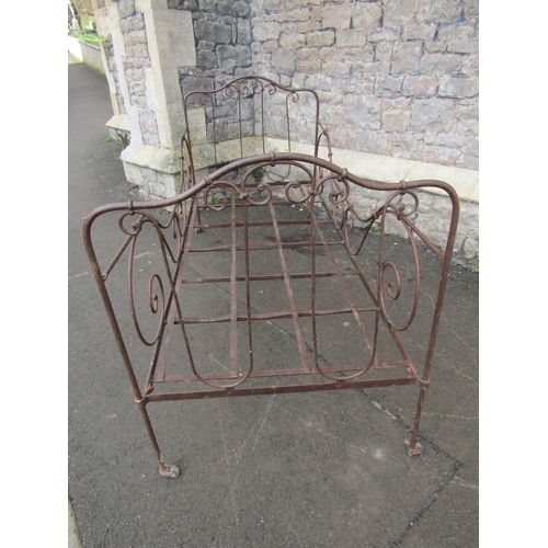 2089 - An antique folding steel bed with decorative scrollwork detail