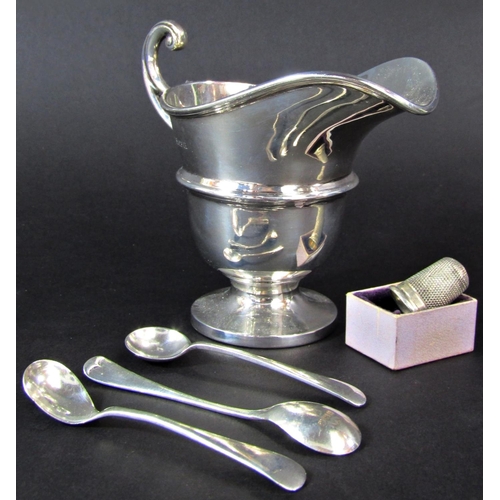 1231 - A cased set of twelve teaspoons and a sugar tong, silver cream jug, three mustard spoons, a thimble,... 